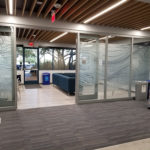 Frosted window graphic privacy film with intricate ,clear, wavy, narrow lines installed on interior conference roomwindows.