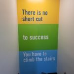 "There is no short cut to success. You have to climb the stairs" Wall Mural installation on inner stairway wall behind landing for Mission Federal Credit Union