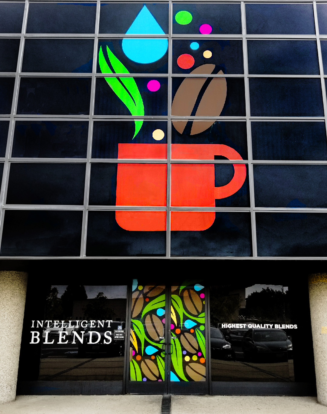 Window Perforation Film on building showing image of bright orange coffee cup, green leaves and bright blue water droplet
