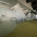 Frosted film lines in large hand fan pattern on interior office windows shot from an angle