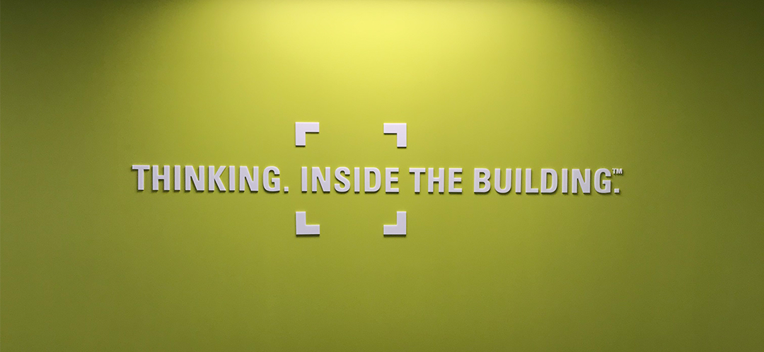 "Thinking. Inside the Building." in white dimensional acrylic letters installed on light green wall