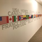 Flags of many nations printed on vinyl and mounted on wall with names of countries printed in collage format
