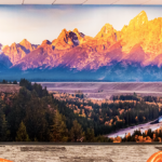 Wall Mural of Mountains in morning sun with oranges, reds, and shadows in violet by meandering river.