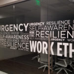 cut white vinyl displaying corporate values in varied thickness fonts on glass viewed from angle